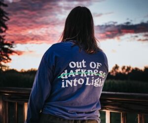 Young woman in blue T shirt focusing on the light instead of darkness